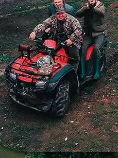 Dois homens em um quadriciclo no campo